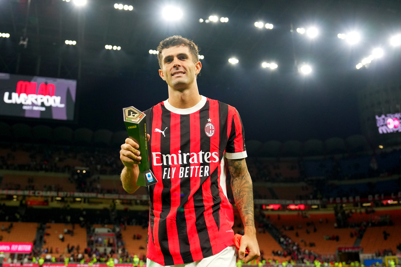 Pulisic sul manto erboso di San Siro con i mano il premio per il miglior giocatore in Milan-Venezia